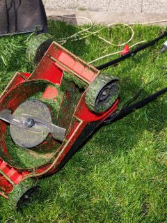 Red lawn mower upside down and container full of grass, Which Side Of The Lawn Mower Blade Is Up?