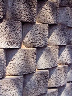 A patterned and rough looking concrete block retaining wall.
