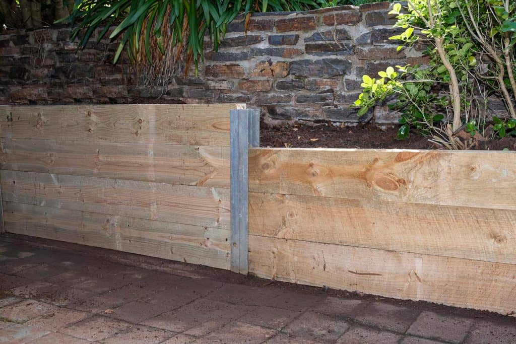 Retaining wall built with pressure treated structural pin