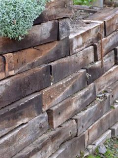 Retaining wall made of wooden sleepers, How Long Do Retaining Walls Last? [Inc. Wood Ones]