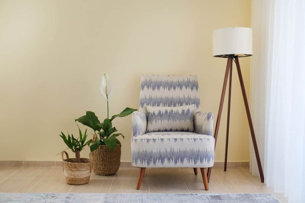 An upholstered chair with plants and a floor lamp on the side, 5 Best Floor Lamps For Plants 