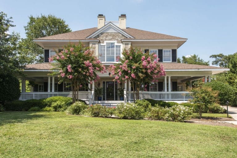 Gorgeous southern home with wrap around white porch and blooming crepe myrtle trees, When Do Crepe Myrtles Bloom?
