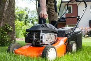 Man turning on the lawn mower by gardener, Why Are Lawn Mowers So Loud?