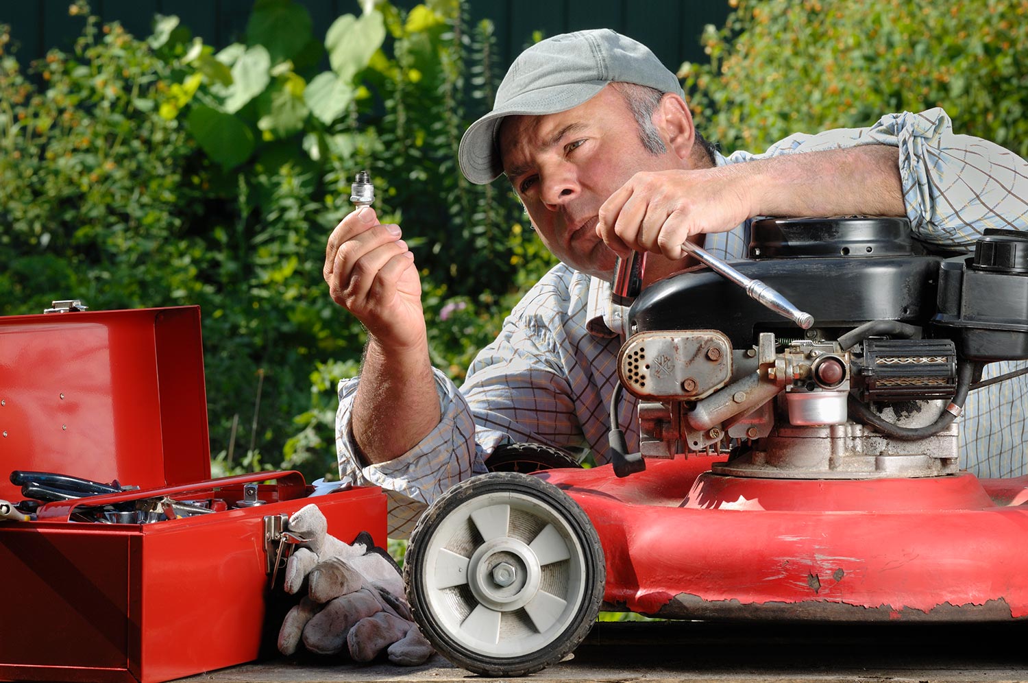 Man working on a lawnmower in the garden