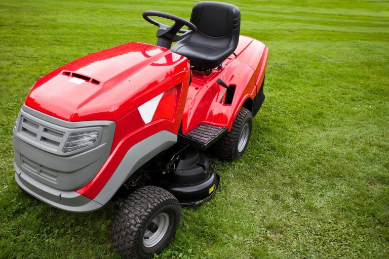 A red riding mower parked on the grass, Can You Tip A Riding Lawn Mower On Its Side Or Back?
