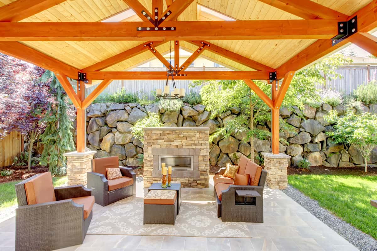 Exterior covered patio with fireplace and furniture.