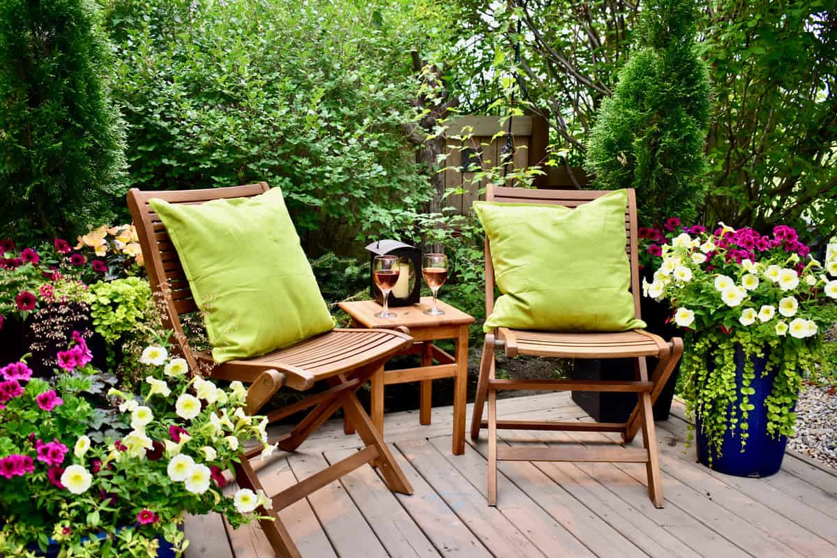 Garden cafe deck with seating for cozy seasonal evenings with beautifully designed flowering planters for lush natural luxury setting