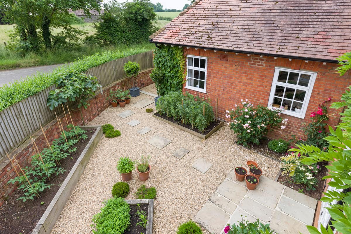 Garden patio UK. Landscaped garden with gravel, raised beds and York stone stepping stones and patio. — Photo