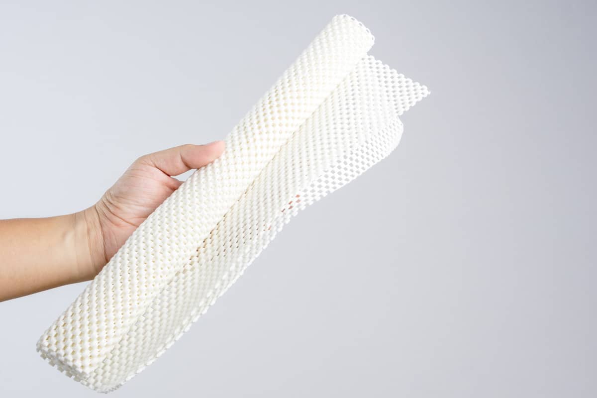 Hand holding white anti slip rubber mat for bathroom or wet floor