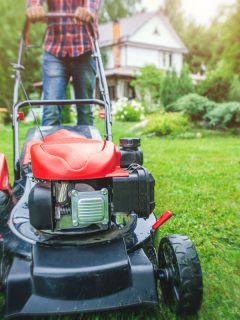 Man using his lawn mower at the backyard, Lawn Mower Stalls When Tilted—What To Do?