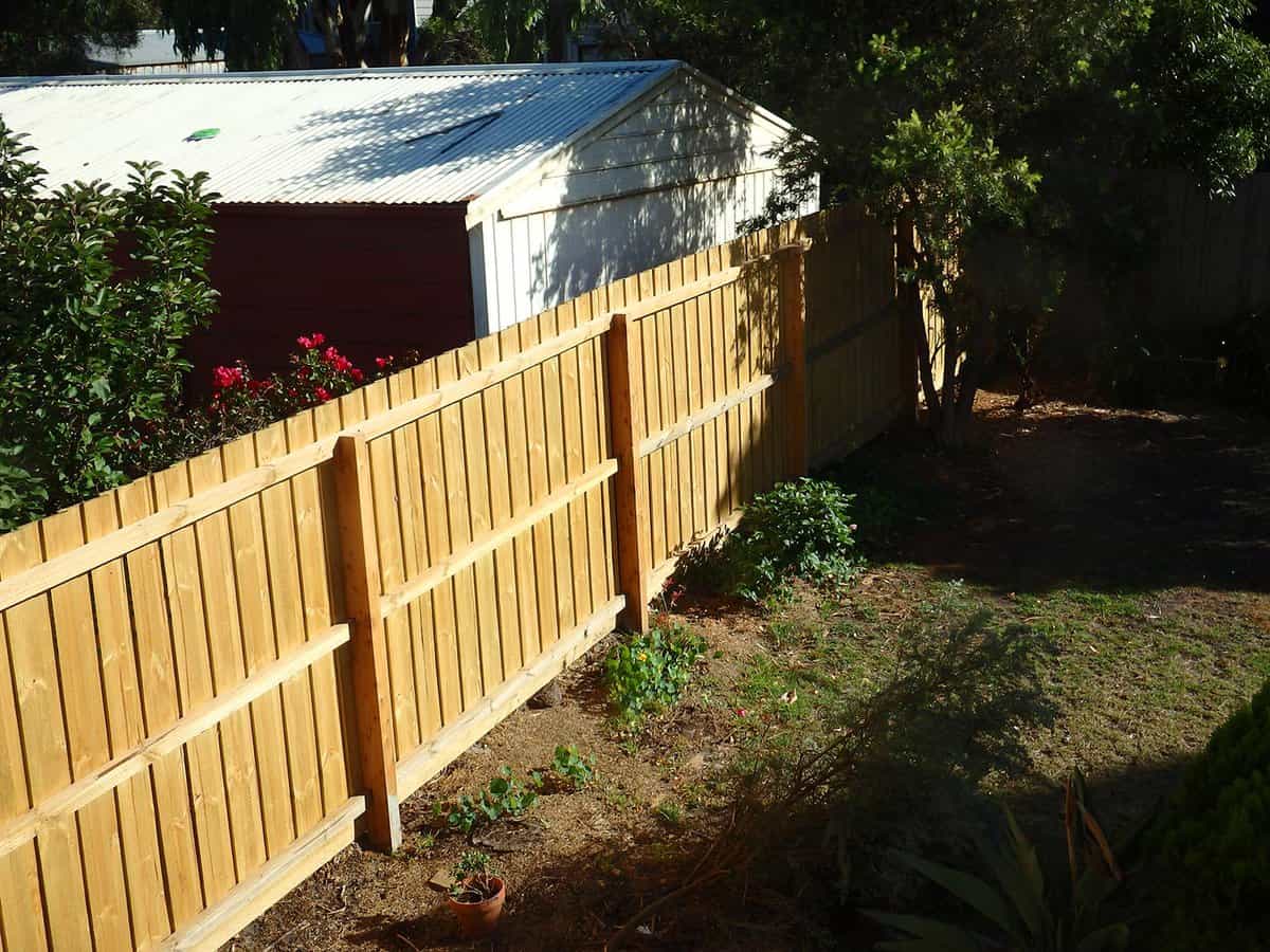 New wooden fence between houses on morning sunshine