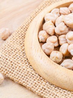 fresh uncooked chickpeas on a brown wooden bowl, close up photo, Can You Grow Beans And Chickpeas From Dried Beans? [Or Fresh!]