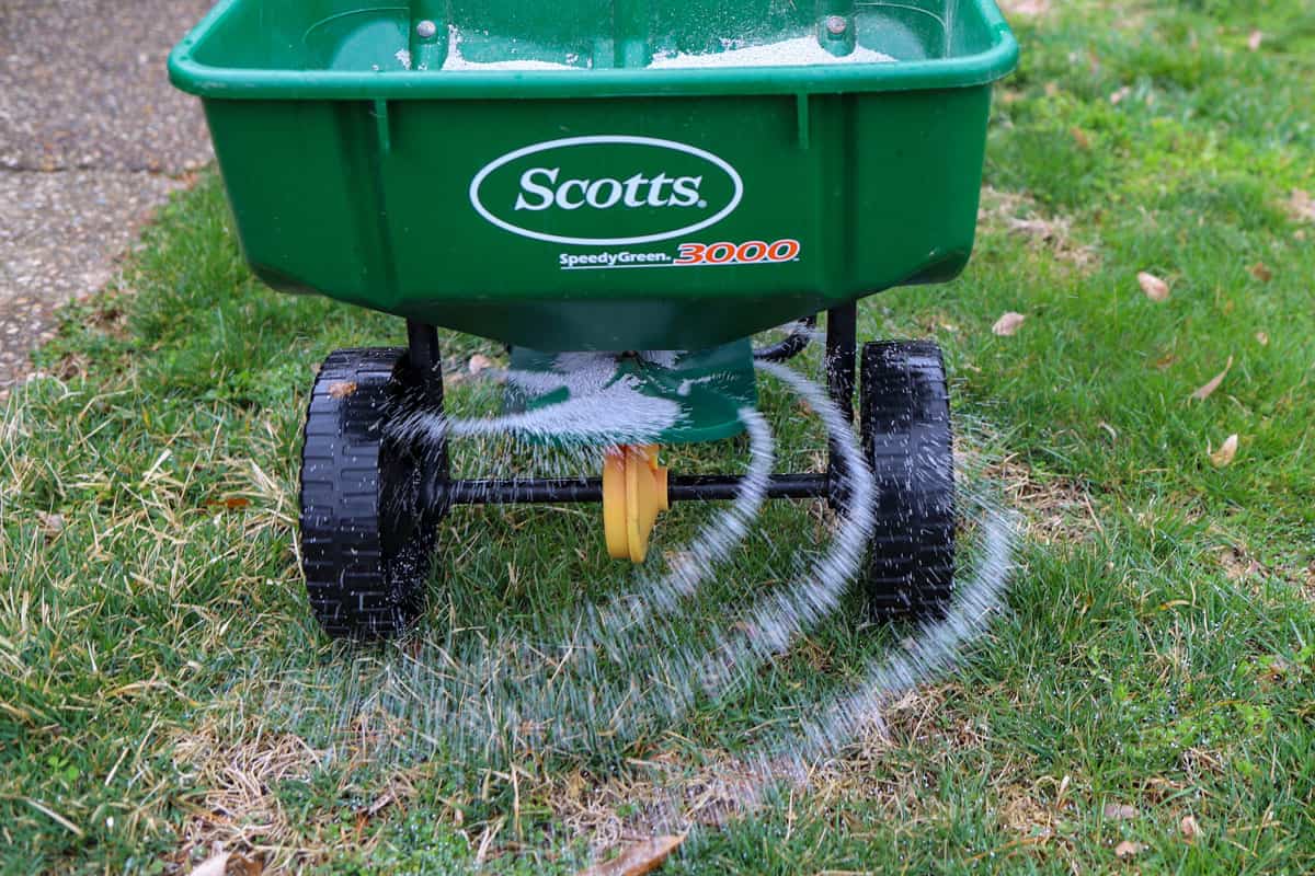 A Scotts seed and fertilizer spreader on a lawn