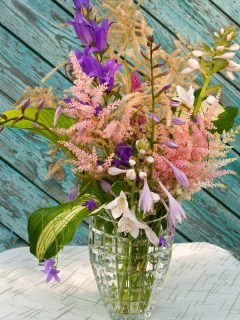 A hosta and bluebells in a glass vase, Can Hosta Grow In Water? [And How To]