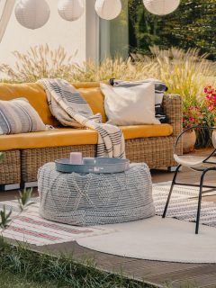 Real photo of an armchair, pouf as a table and wicker couch on a terrace - 15 Gorgeous Wooded Backyard Ideas