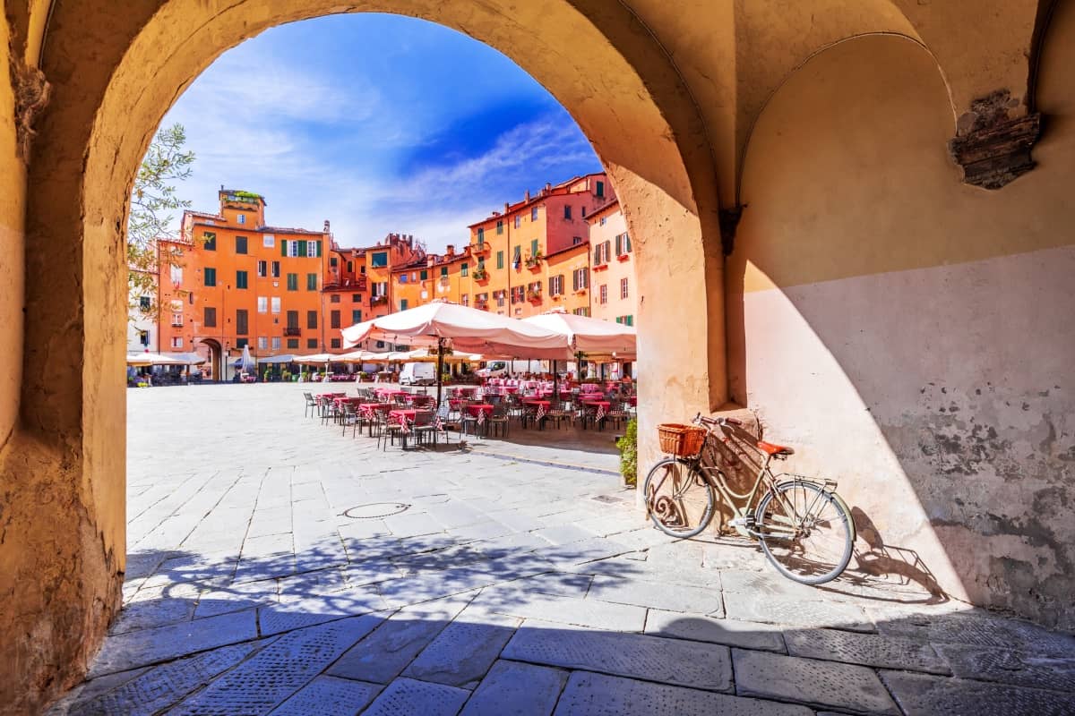 Under A Tuscan Sun - Lucca, Italy - View of Piazza dell'Anfiteatro square through the arch, ancient Roman Empire amphitheater, famous Tuscany