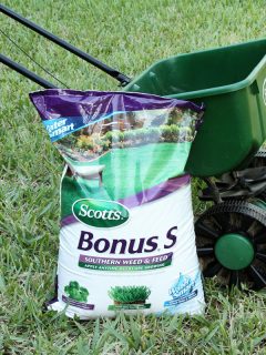 a bag of Scotts Southern Weed and Feed leaning against a Scotts Spreader, When To Apply Scotts Step 4 [And How To]