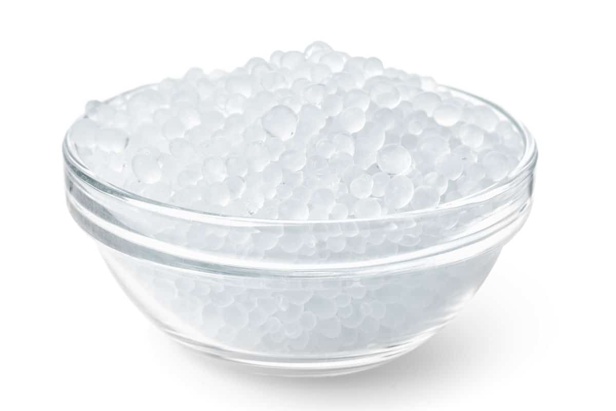photo of a glass bowl full of silica gel granules, round silica gels