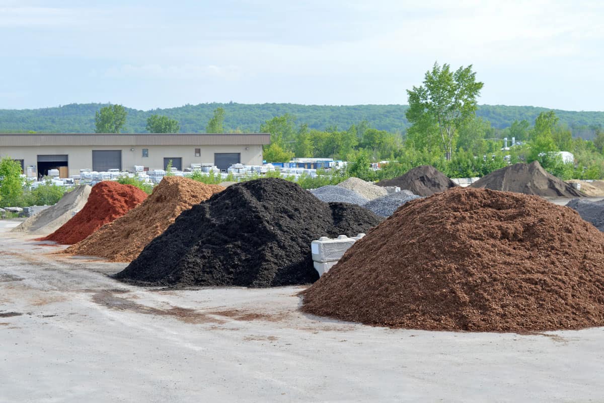 various stone and cedar mulch piles separated into various types for packaging in the warehouse
