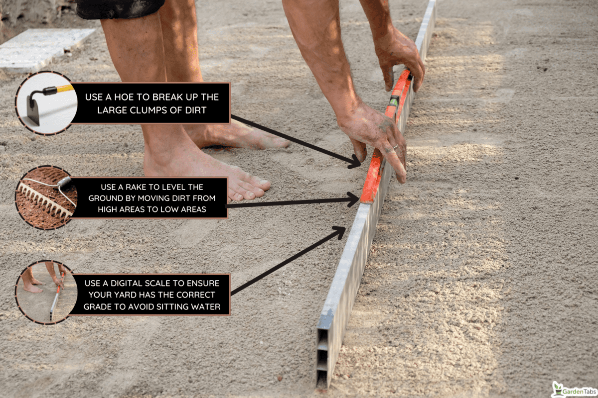 A barefoot man levels the sandy platform with an aluminum bar in his yard - How To Level Yard After Tilling (Inc. By Hand, Lawn Roller, And Best Tools To Smooth The Ground)