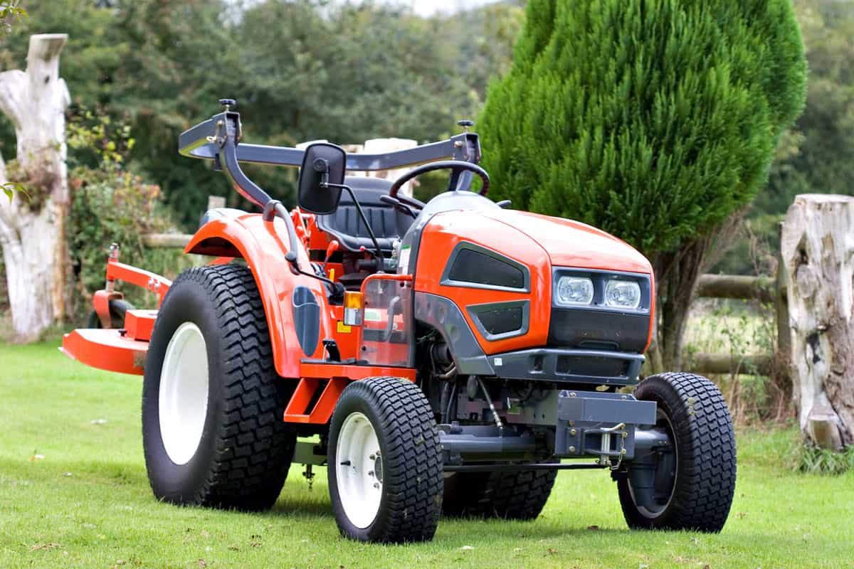 A bright red tractor on green grass