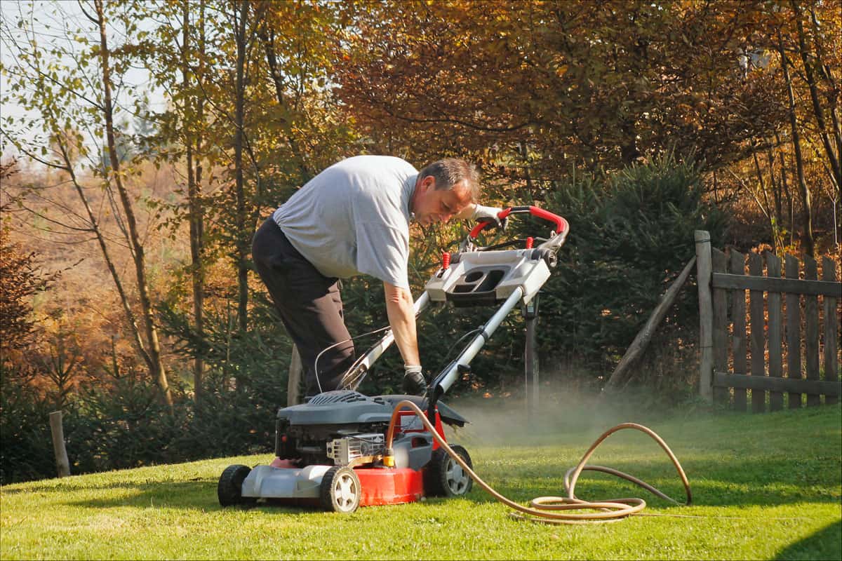 Autumnal works old man cleaning some lawn mower