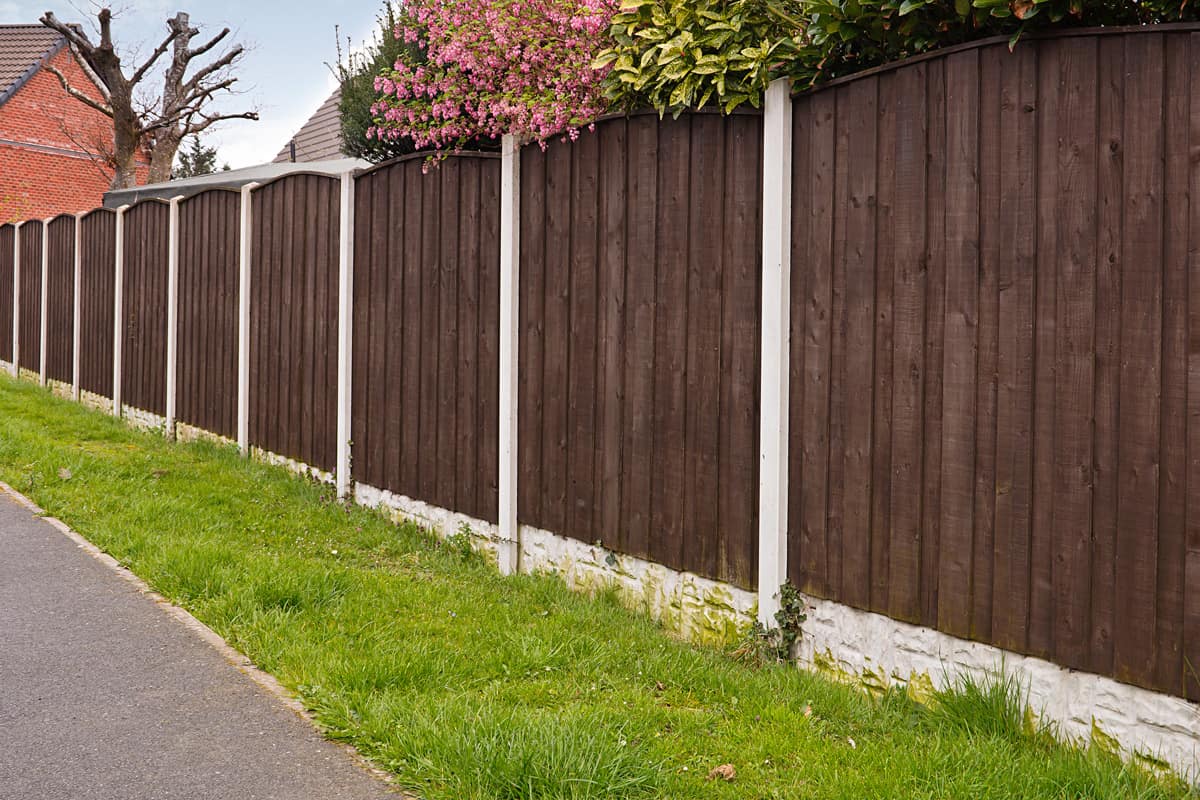 Close board fence erected around a garden for privacy with wooden fencing panels, concrete posts and kickboards for added durability.