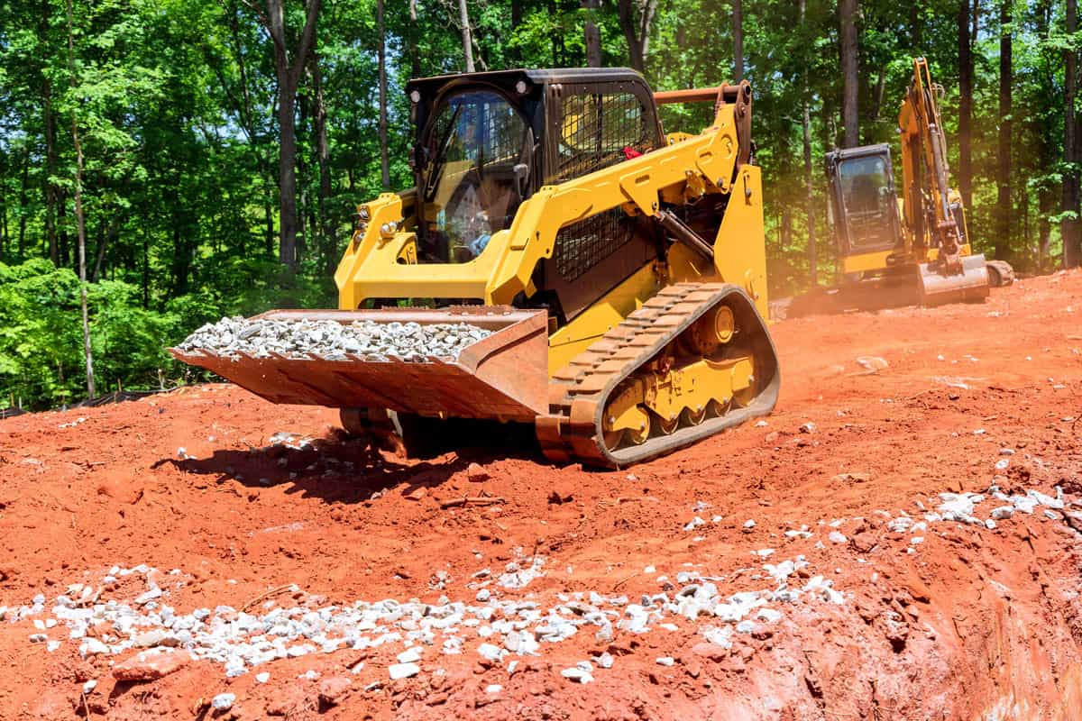 Excavation at a construction site, mini loader bobcat transports crushed stone to different construction places