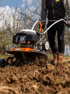Farmer plows the land with a cultivator, preparing it for planting vegetables, What Is The Best Garden Cultivator [Inc. Battery, Electric, And Gas]?