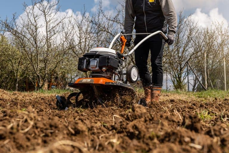 Farmer plows the land with a cultivator, preparing it for planting vegetables, What Is The Best Garden Cultivator [Inc. Battery, Electric, And Gas]?