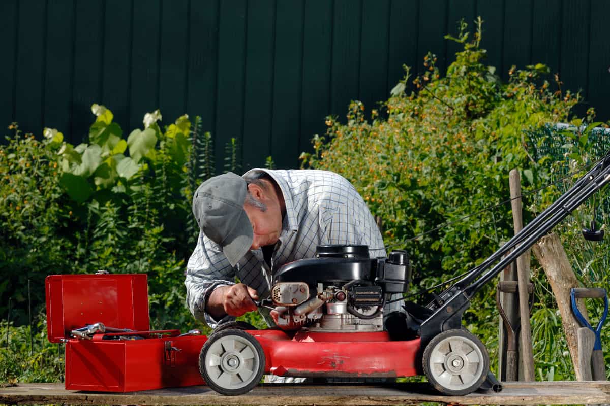 Man working on a lawnmower fixing repairing