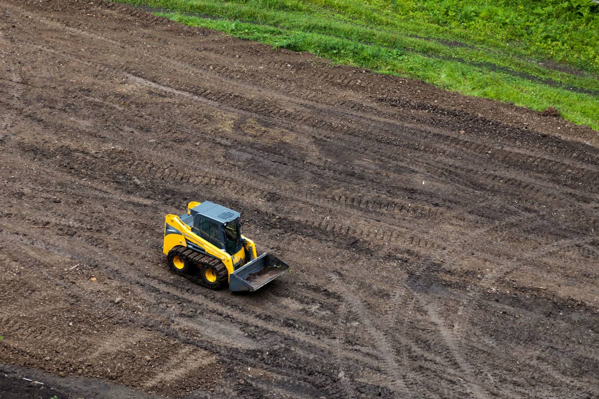 Mini digger bulldozer on the mud field