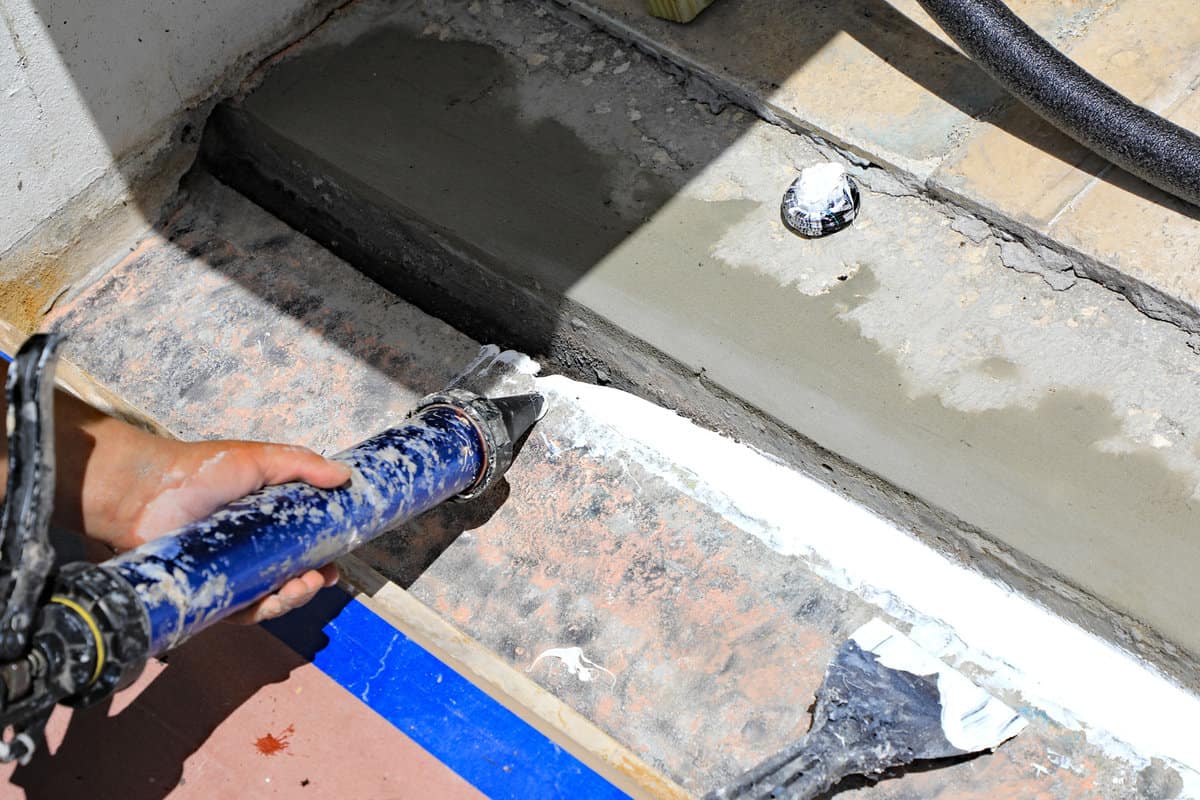 Repair of an expansion joint between two buildings involves caulking, and cement. This is a new repair done by a professional.