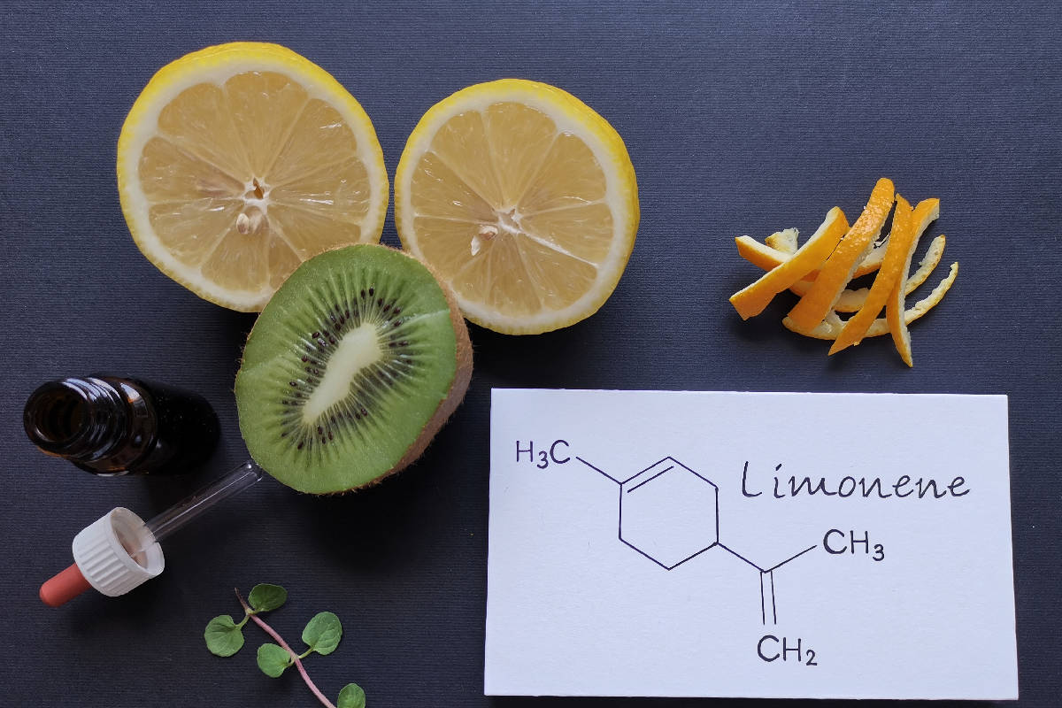 Structural chemical formula of limonene with fresh citrus fruit and a glass bottle of essential aroma oil
