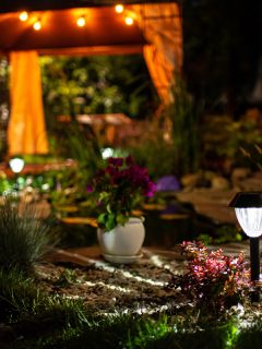 Decorative Small Solar Garden Light, Lanterns In Flower Bed. Garden Design. Solar Powered Lamp, Do You Leave Solar Lights On All The Time? Should You?