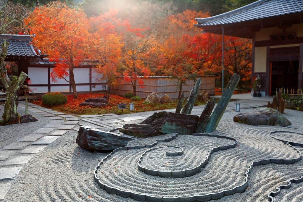 Fall scenery of a Japanese rock garden (zen garden, dry landscape or karesansui) in morning sunlight, at Honryutei in Enkouji, a Buddhist Temple famous for its fiery maple foliage in Kyoto, Japan