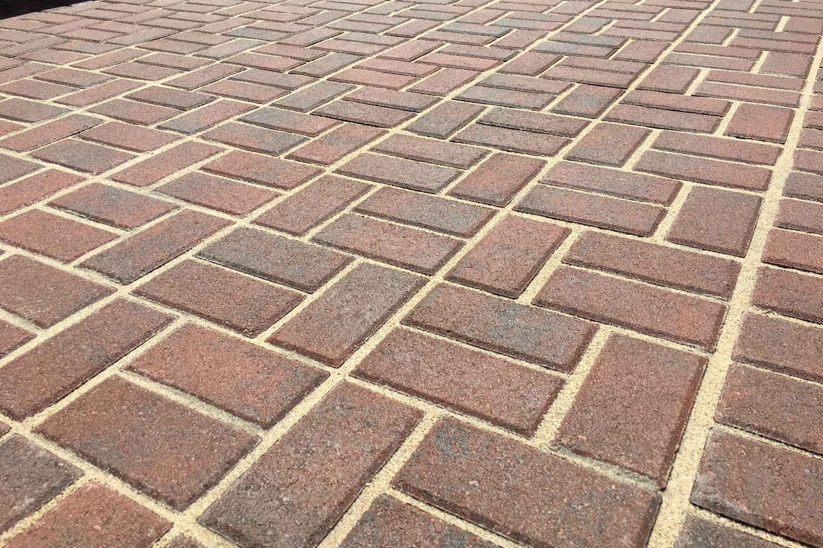 Pattern of red pavers with sand.
