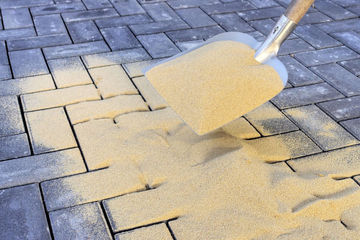 Sweeping in joint sand on a construction site