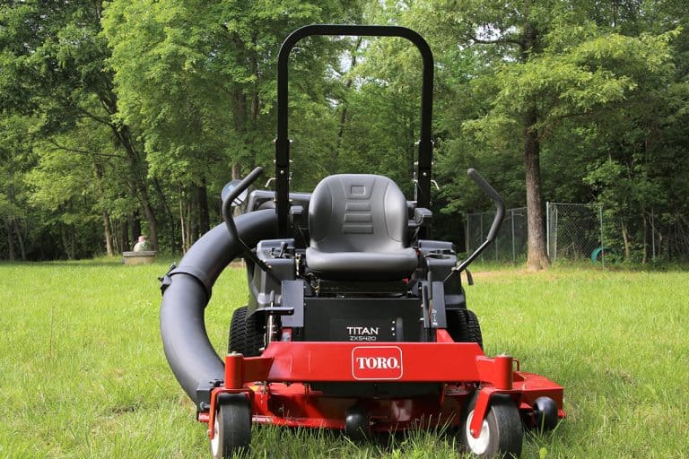 Toro Titan zero turn lawn mower with bagger attached in yard of grass, Do Toro Mowers Take Regular or Mixed Gas?
