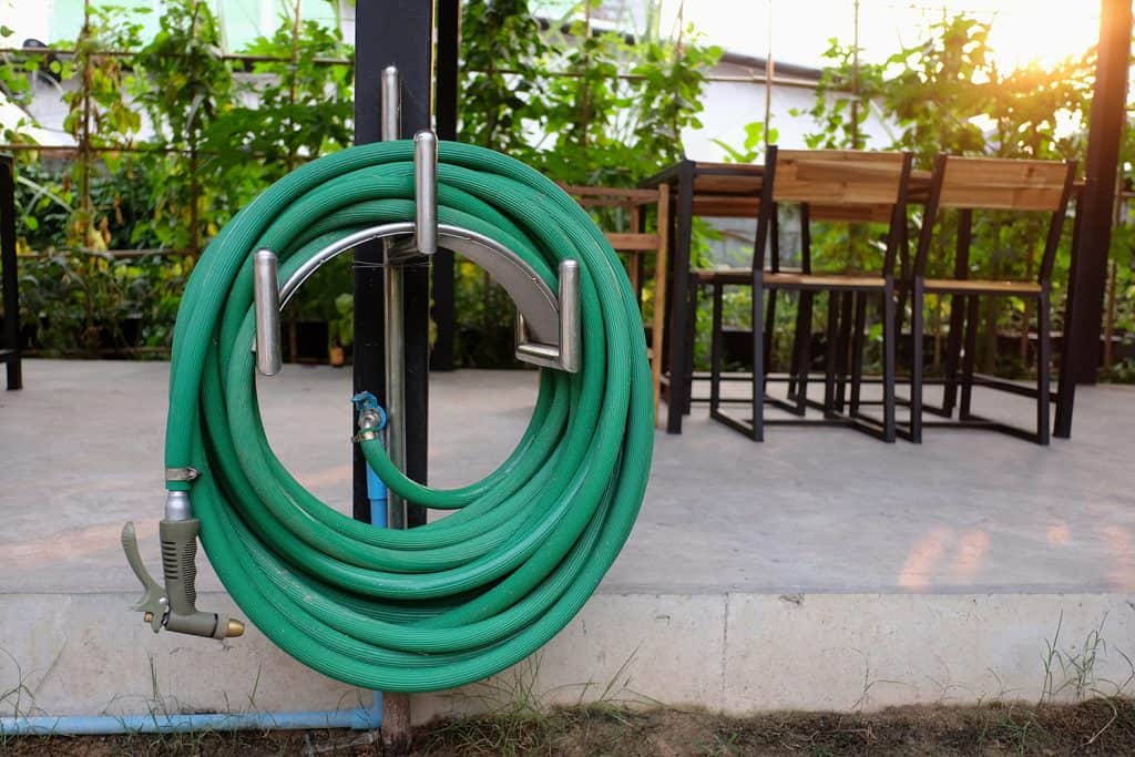 Green watering hose in the garden