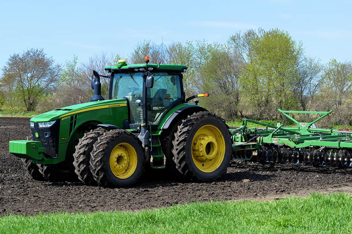 John Deere 8345R tractor pulling lawn aerator
