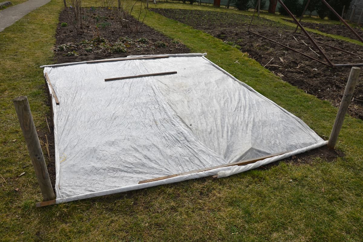 the gardener covered the white breathable foil bed