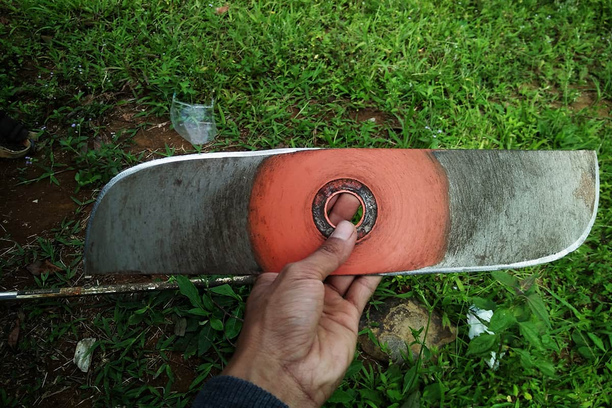 Brush cutter knife that is being held after sharpening