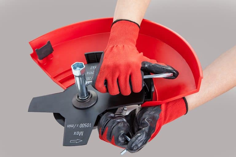 Hands working with wrench mounting a blade on the new edger, How To Remove An Echo Edger Blade [Step By Step Guide]
