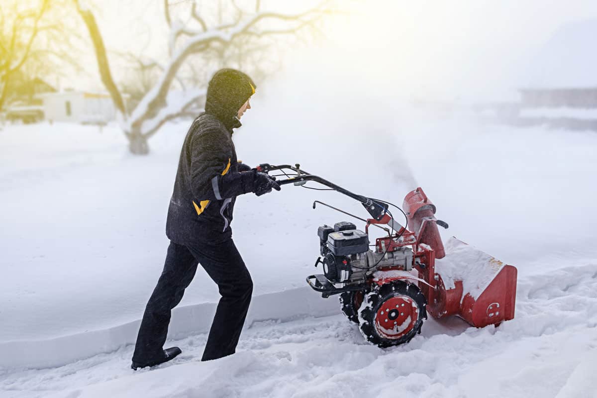 Man using a snow blower to clear his driveway