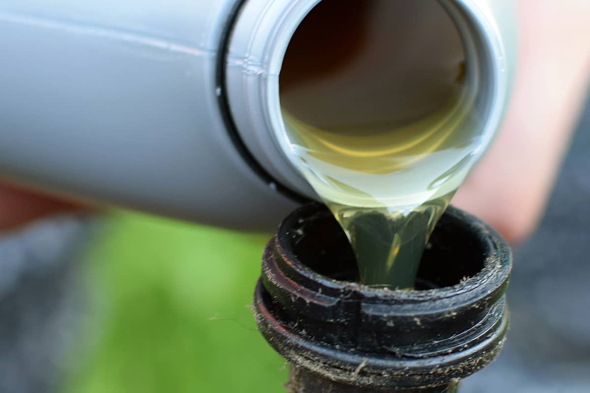 Pouring oil to riding lawn mower
