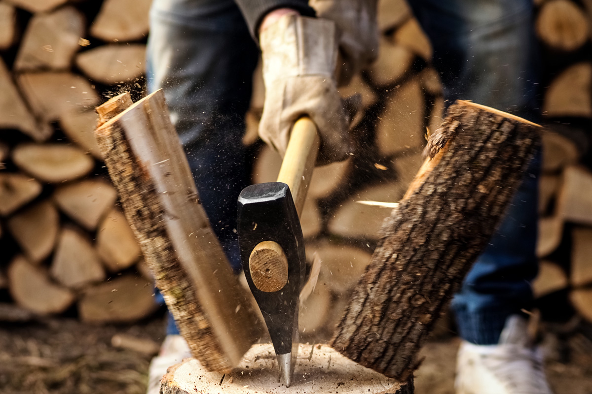 Splitting of a firewood with an ax, close up.