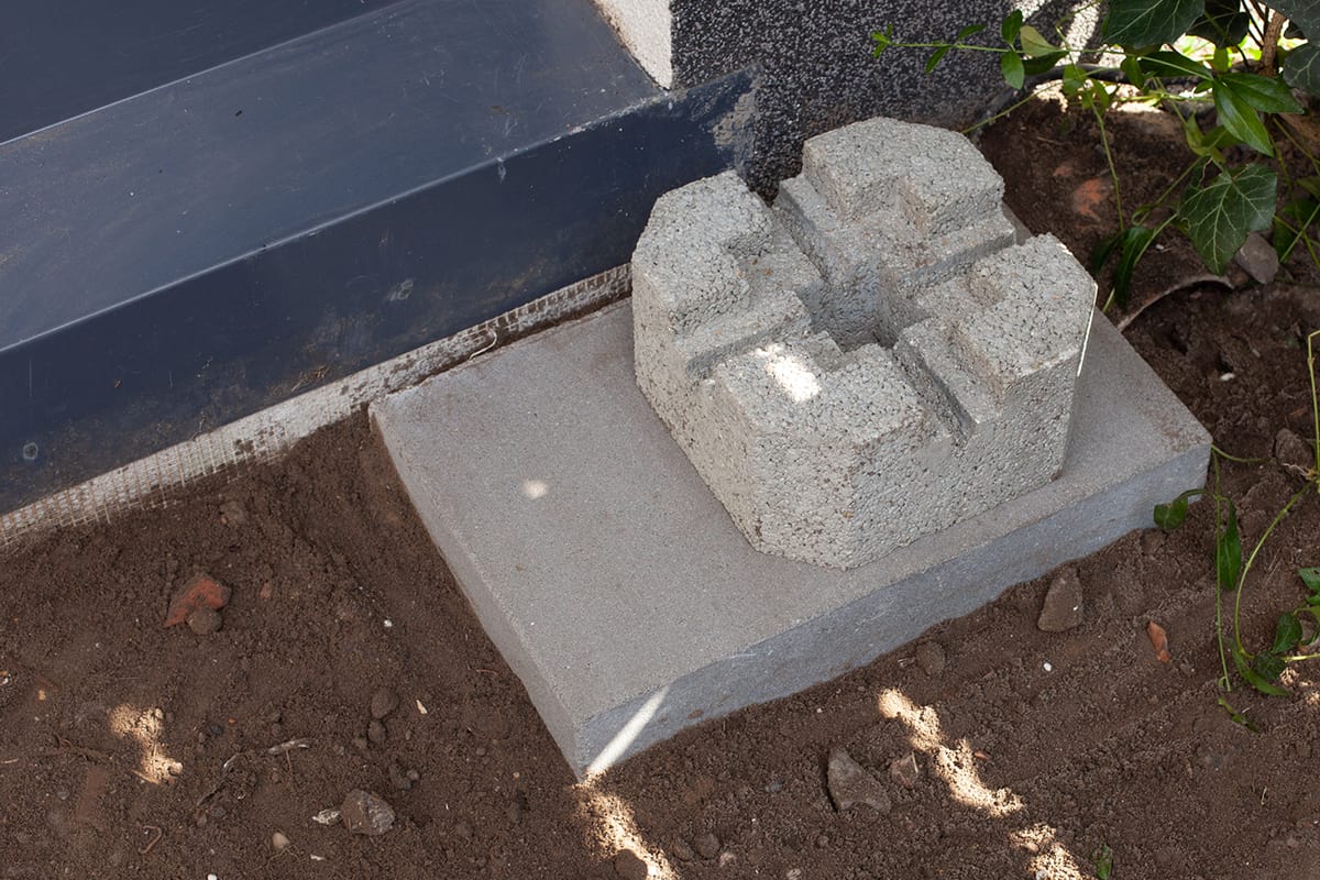 A shot of a cement deck block foundation installed on the ground