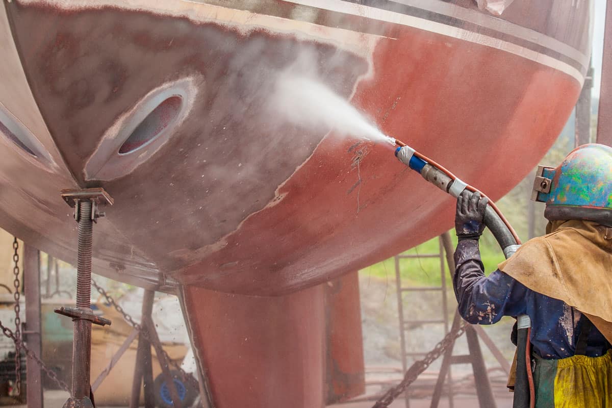 Cleaning the the underside of a boat using a sandblaster