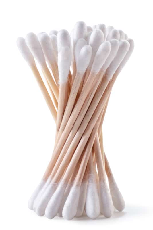 Cotton swabs on a wooden base for the ears close-up on a white background.